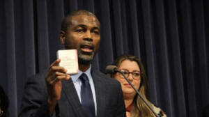 State Rep. LaShawn Ford, D-Chicago, holds up a box of medication during a news conference in Springfield
