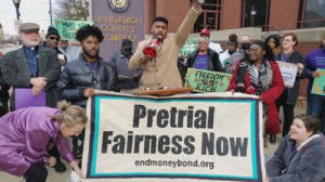 Advocates for ending cash bail in Illinois hold a vigil outside the Sangamon County courthouse in Springfield